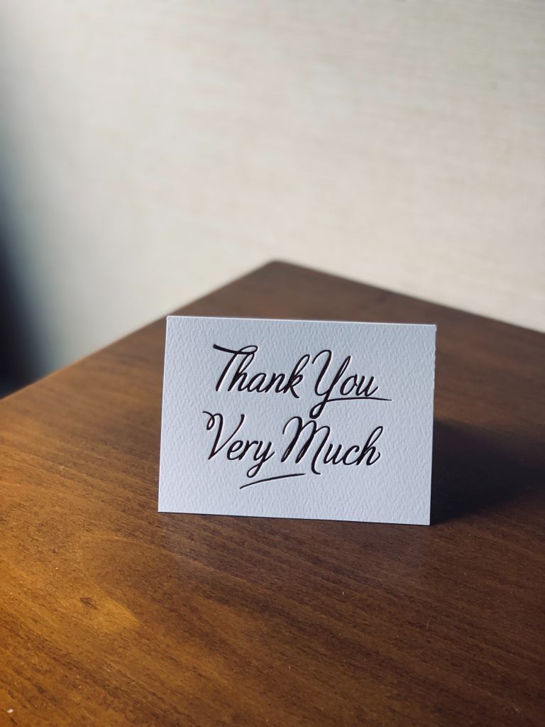 Card on wooden table reads "Thank You Very Much"