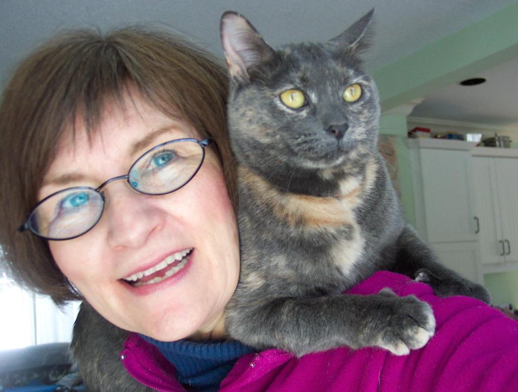 Photo of Marie-Lynn Hammond with grey cat perched on her shoulders.