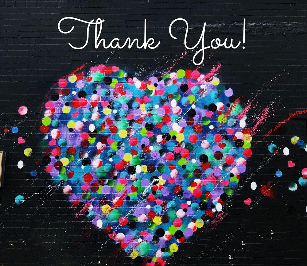 The words "Thank you!" in cursive script on a black background above a huge heart made up of colourful confetti.