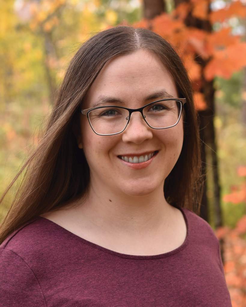 A headshot of Erin Alladin with trees in the background