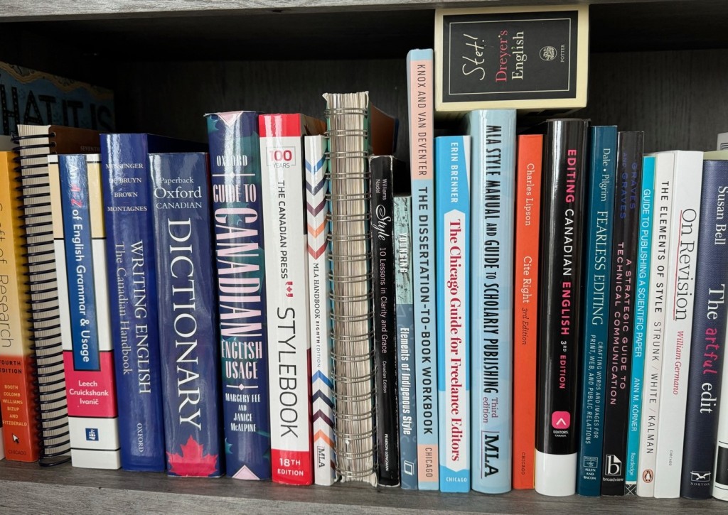 A shelf is lined with approximately 20 books of various sizes and colours.
