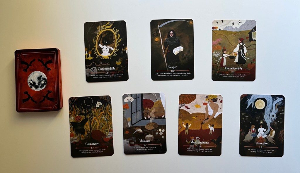 An oracle deck with seven different oracle cards spread on a table.