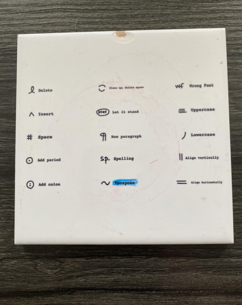 A coaster with proofreading marks as design.